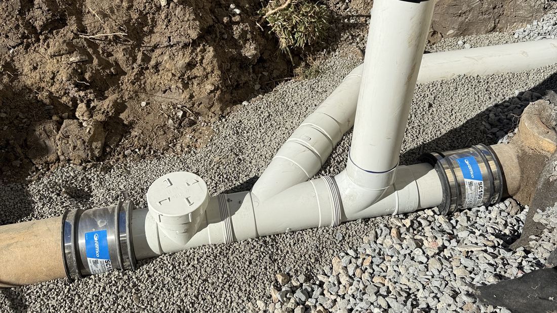 Newly installed PVC drainage pipework and junctions in a trench during a drain repair and replacement by Senco Plumbing in Brisbane